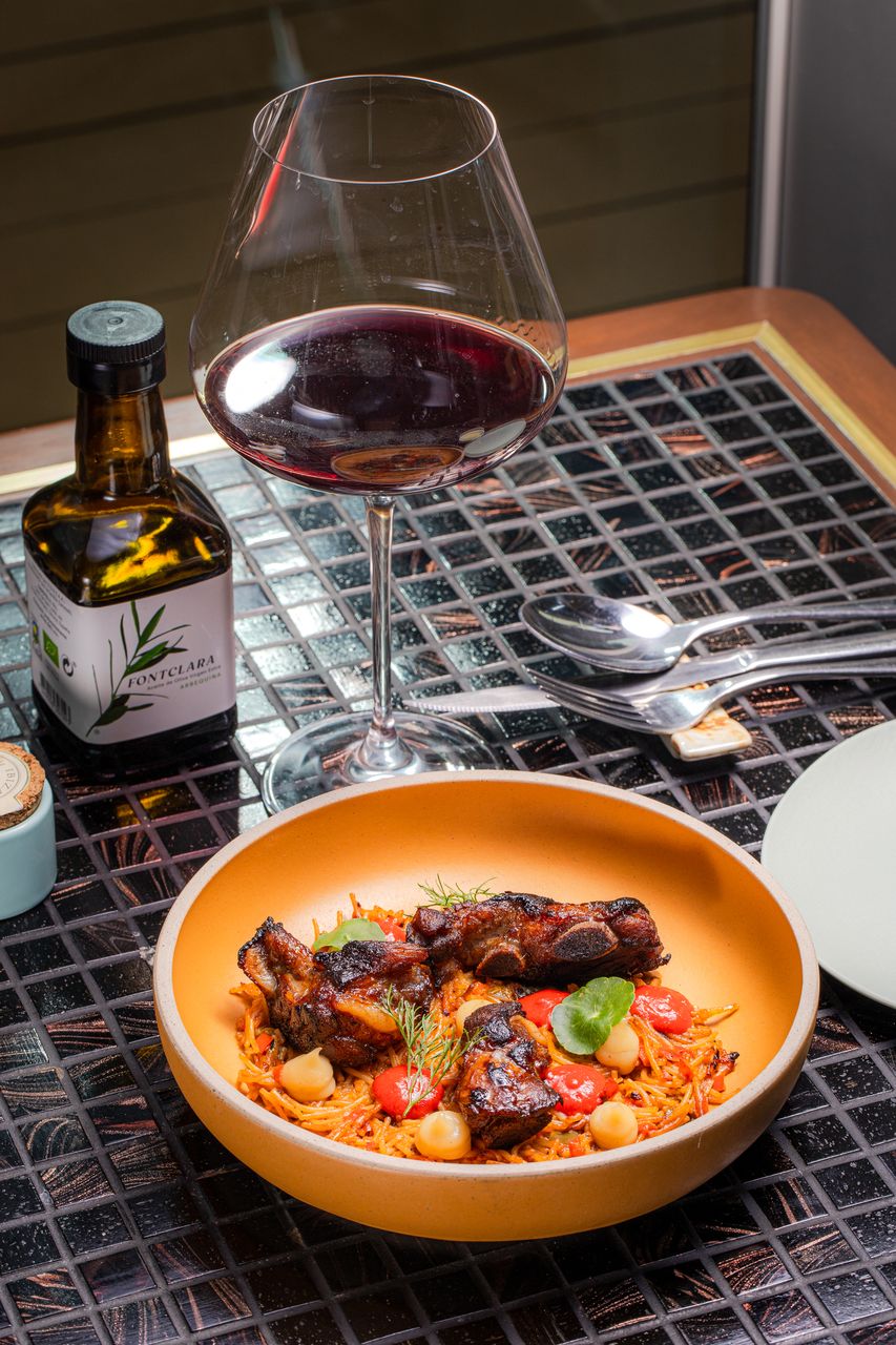 Pork rib over angel-hair fideuà, cooked and served in the pan